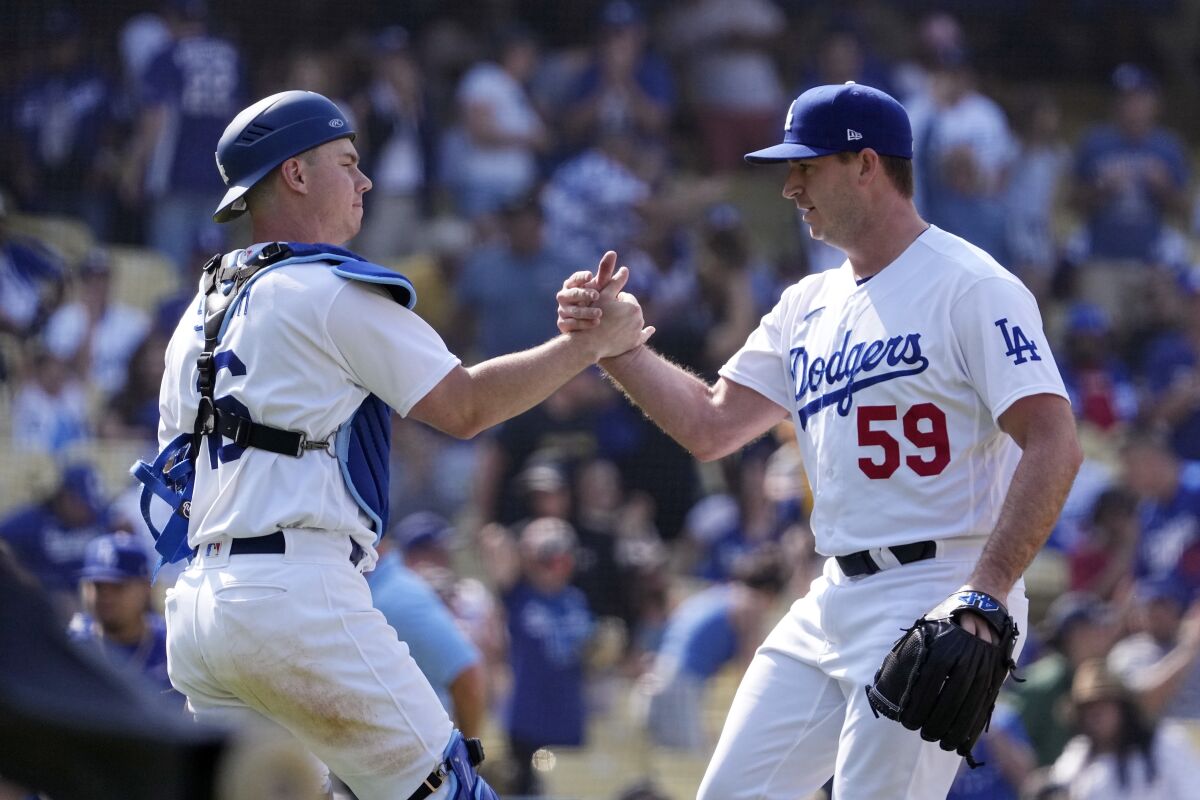 Dodgers' Will Smith, left, and Evan Phillips greet each other after a 6-3 win over the St. Louis Cardinals on Sunday.