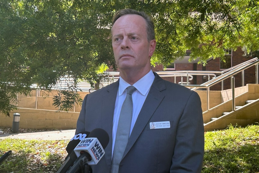 Man with grey hair and suit in front of Nowra Police Station