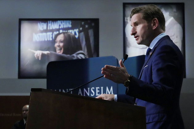 Dean Phillips addresses guests near a photograph of Vice President Kamala Harris.