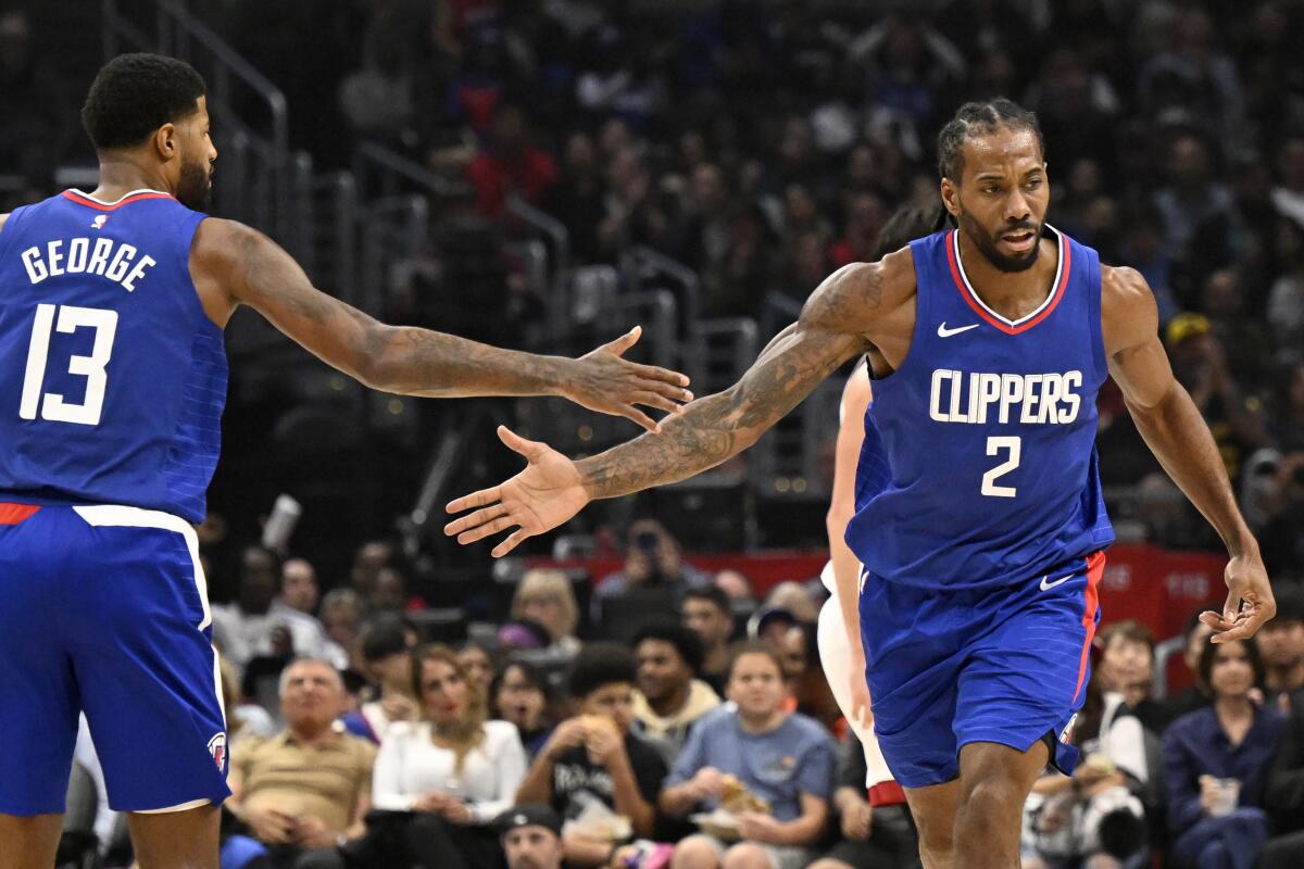 Clippers forward Kawhi Leonard, right, is congratulated by forward Paul George after making a basket.