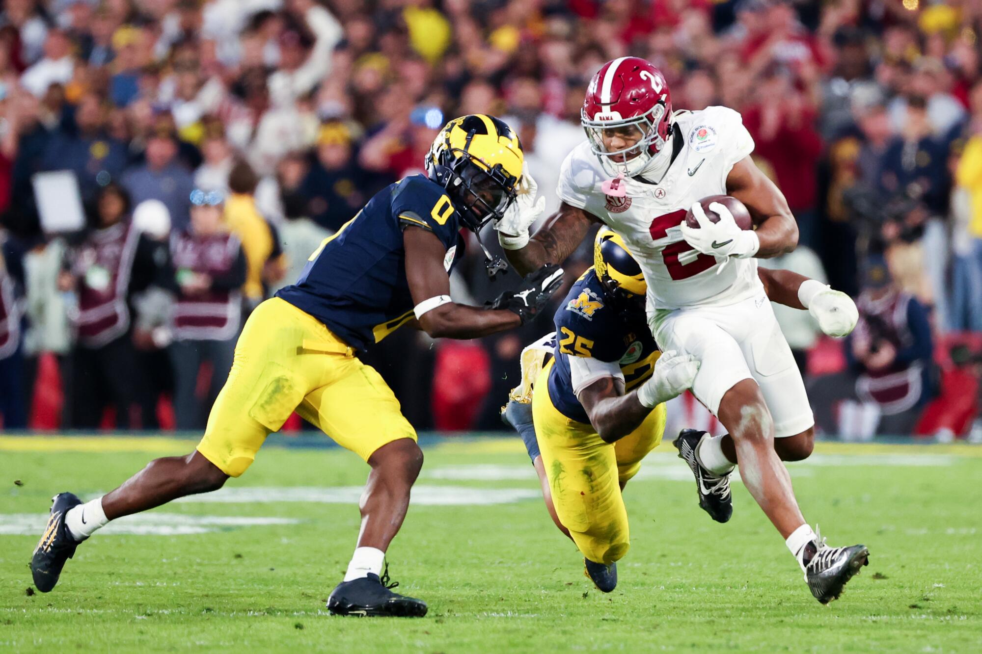 Alabama tailback Jase McClellan runs the ball under pressure from Michigan's Junior Colson and back Will Johnson 