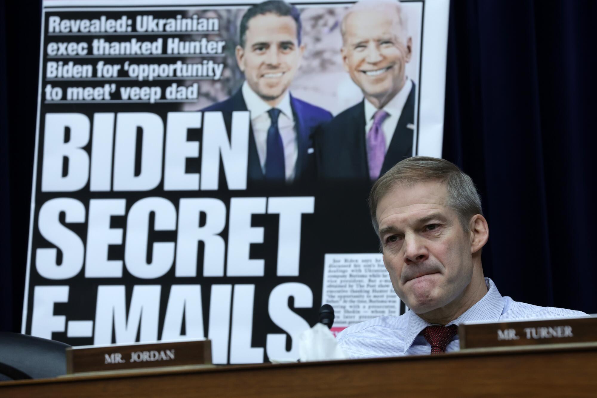 With a poster of a New York Post front page story about Hunter Biden's emails on display, U.S. Rep. Jim Jordan (R-OH) listens