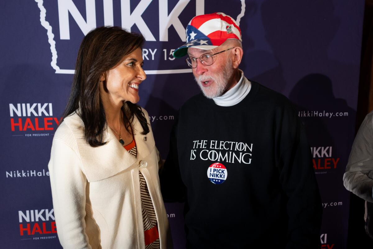 Nikki Haley speaks to a man wearing U.S. flag-themed headgear