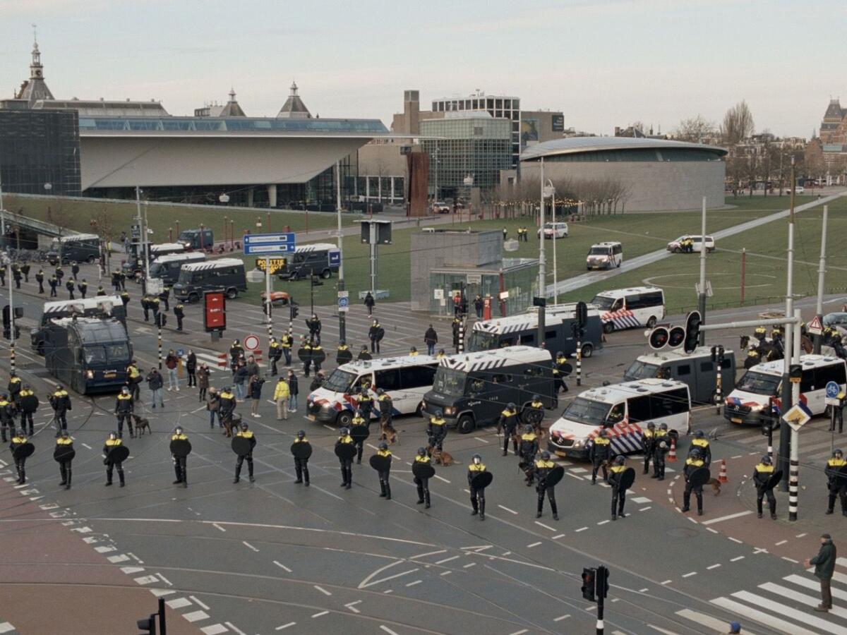 Uniformed police officers stand on a street in Amsterdam.