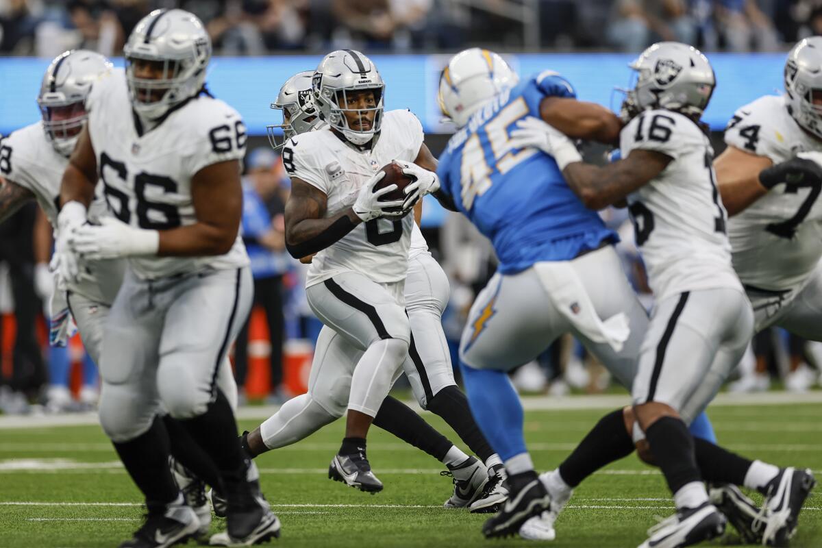 Chargers linebacker Tuli Tuipulotu (45) fights through blockers to close on Raiders running back Josh Jacobs (8).