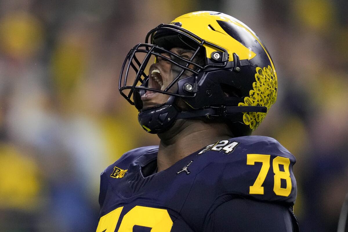 Michigan defensive lineman Kenneth Grant celebrates after sacking Washington quarterback Michael Penix Jr.