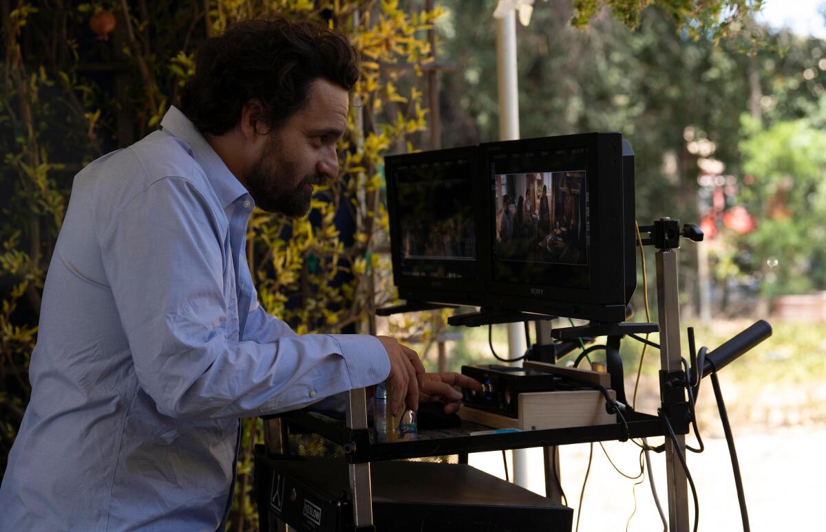 A man on a TV set watching a video monitor