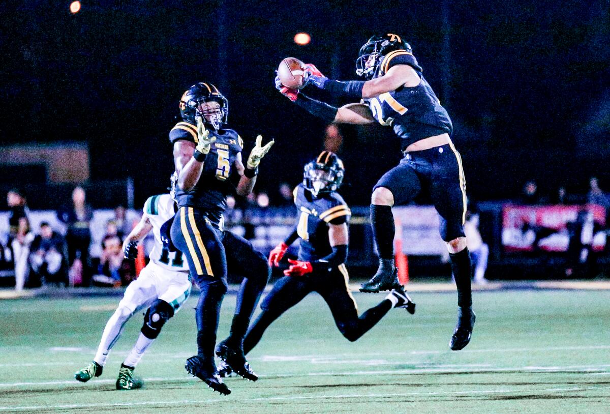 Shane Rosenthal of Newbury Park comes up with interception against Thousand Oaks with Jaden Mack looking on.