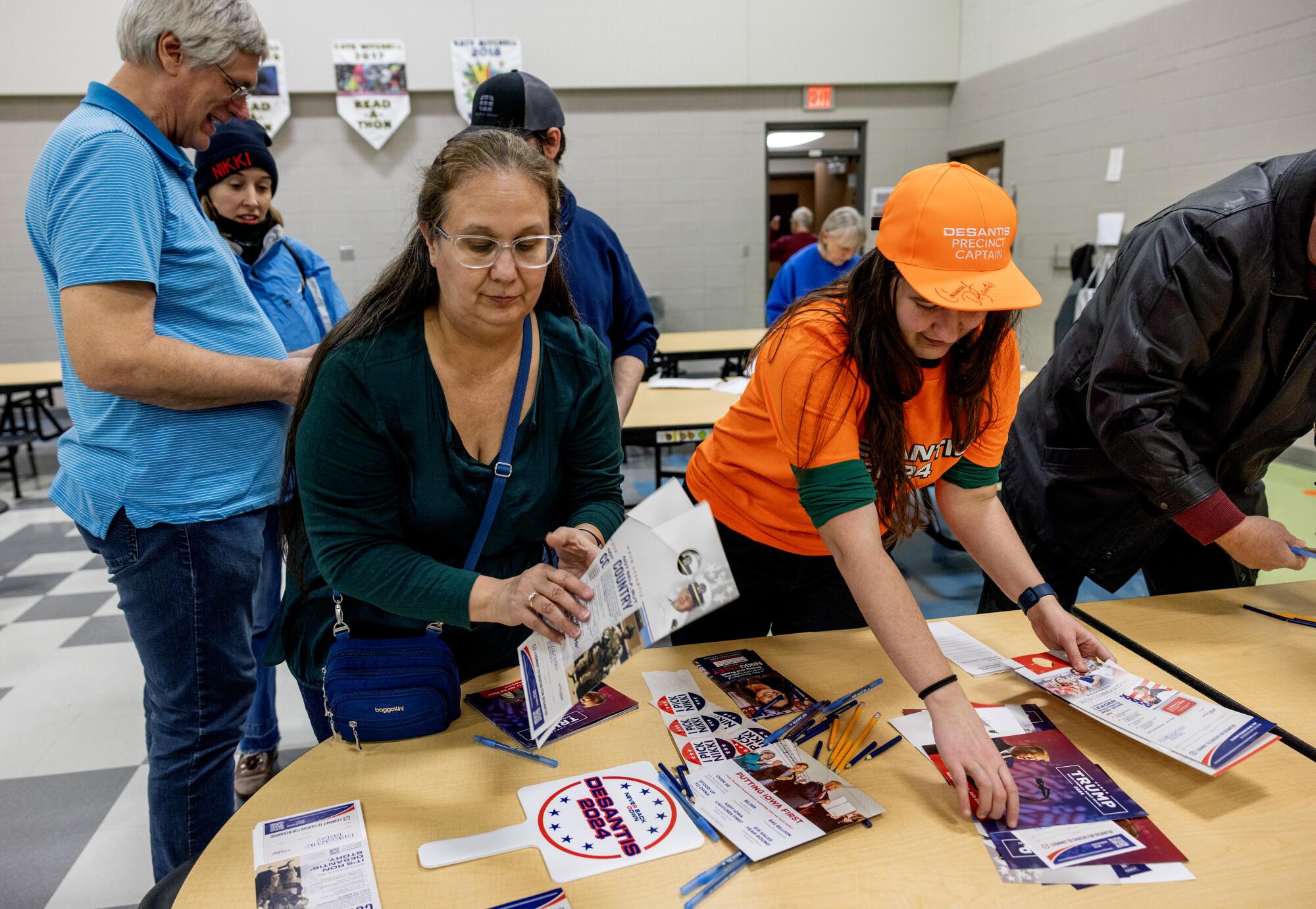 Natalia Porter, left, helps her daughter Deborah Stoner gather Ron DeSantis fliers.