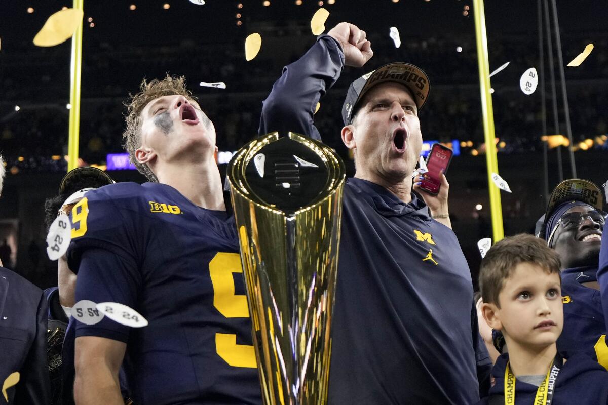 Michigan quarterback J.J. McCarthy, left, and coach Jim Harbaugh let out a yell while celebrating their national championship