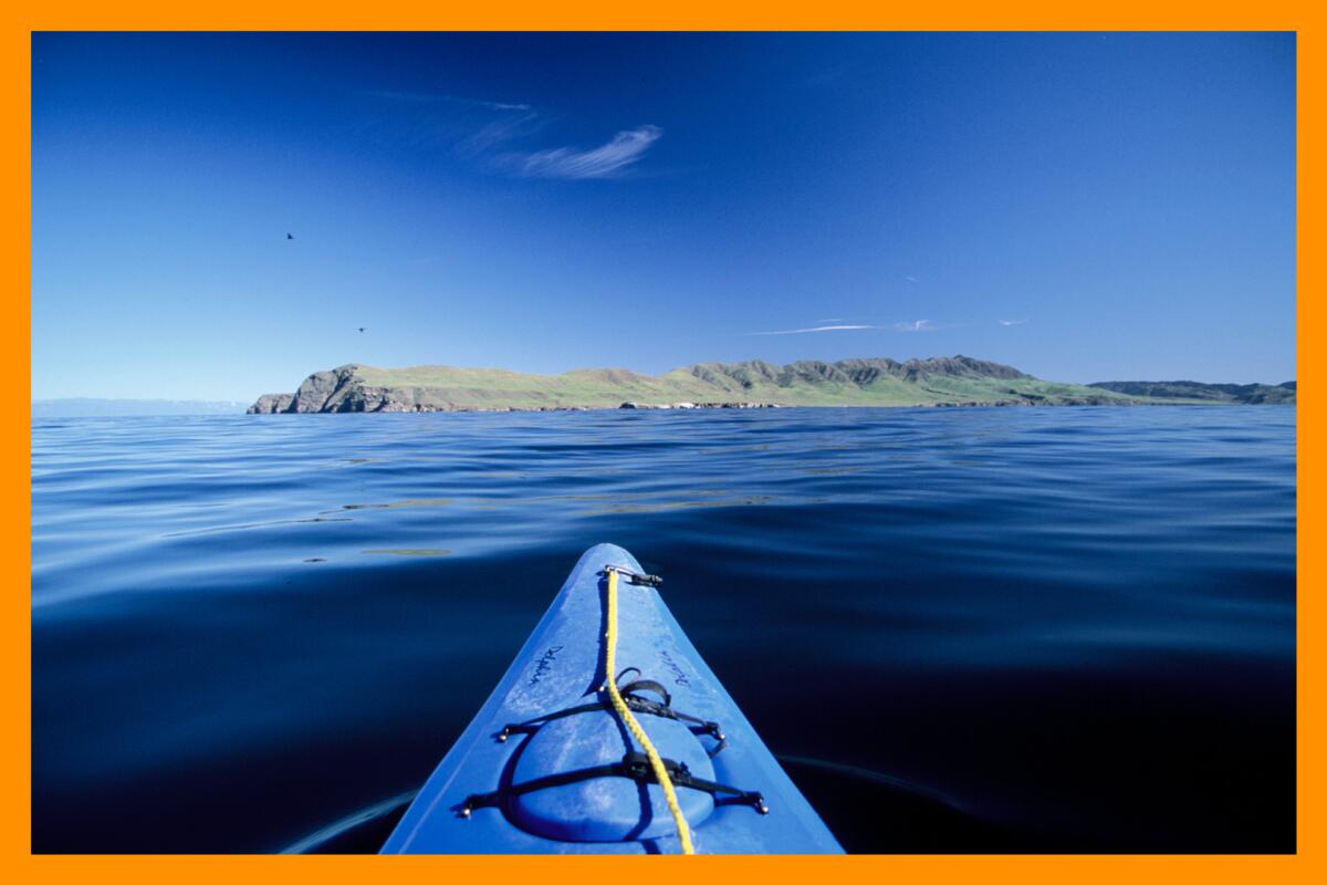 A photo of an island in the distance, taken from a kayak in the water