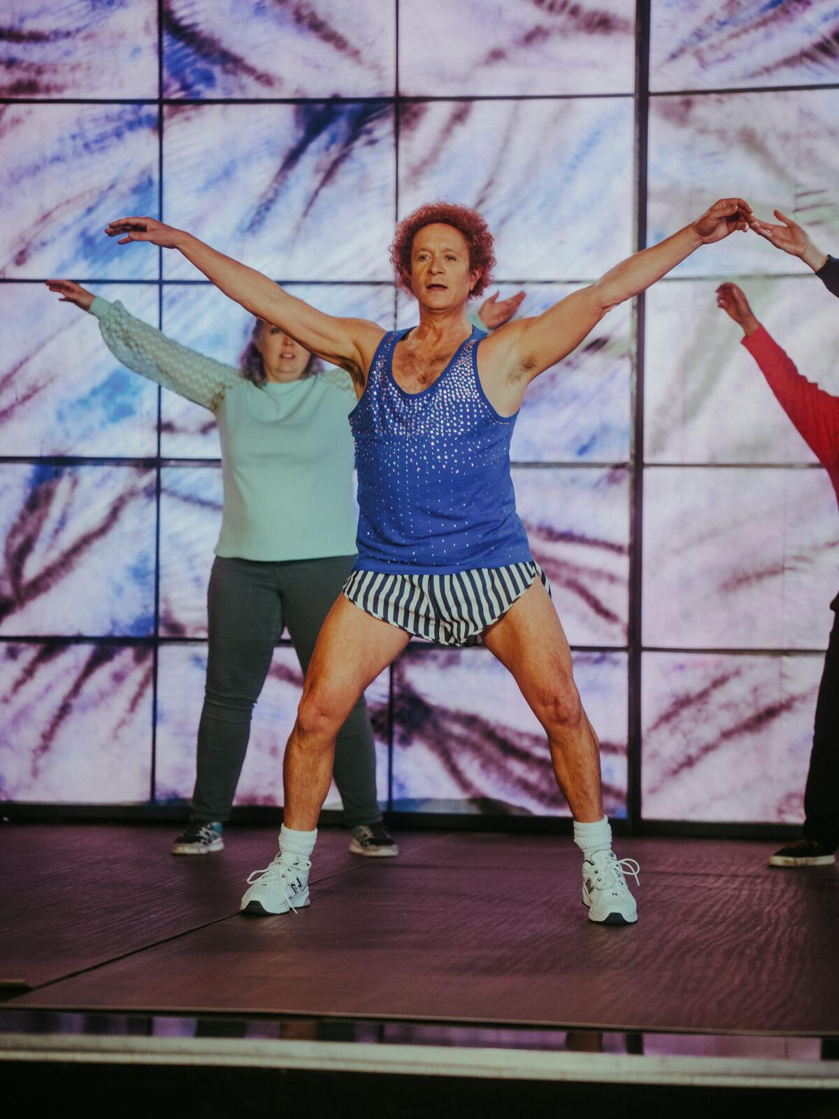 A man and backup dancers on stage