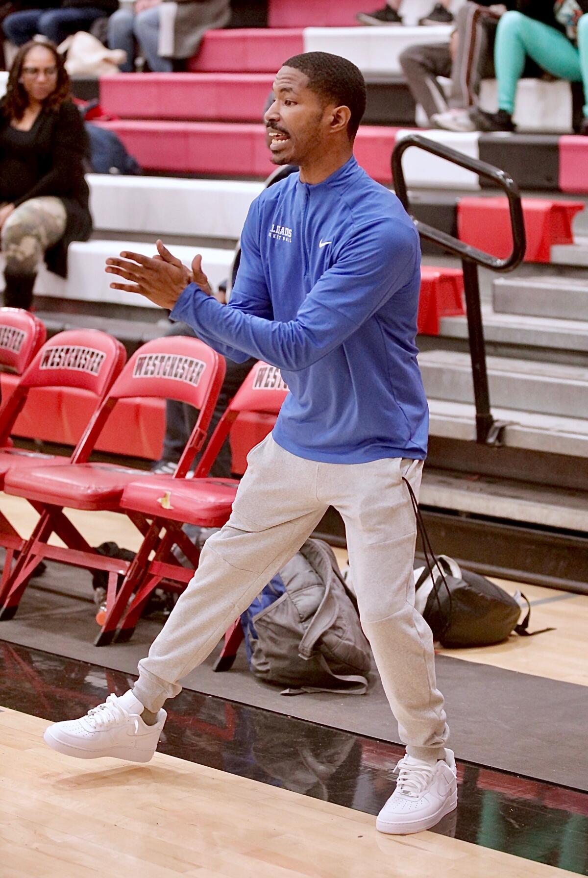 Interim coach LeBre Merritt claps along the sideline as he encourages his Palisades players during an upset of Westchester.