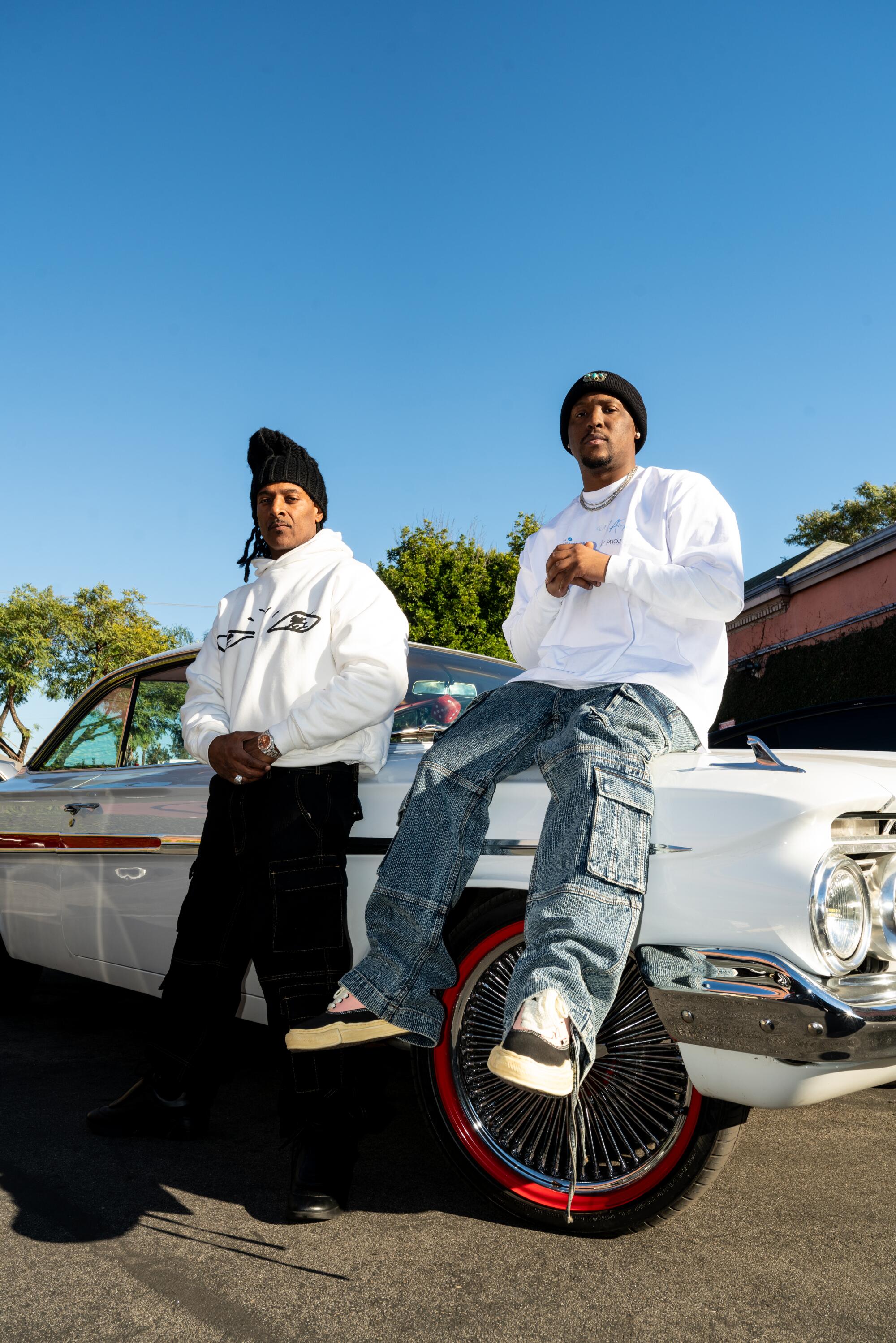 Two men in front of a car.