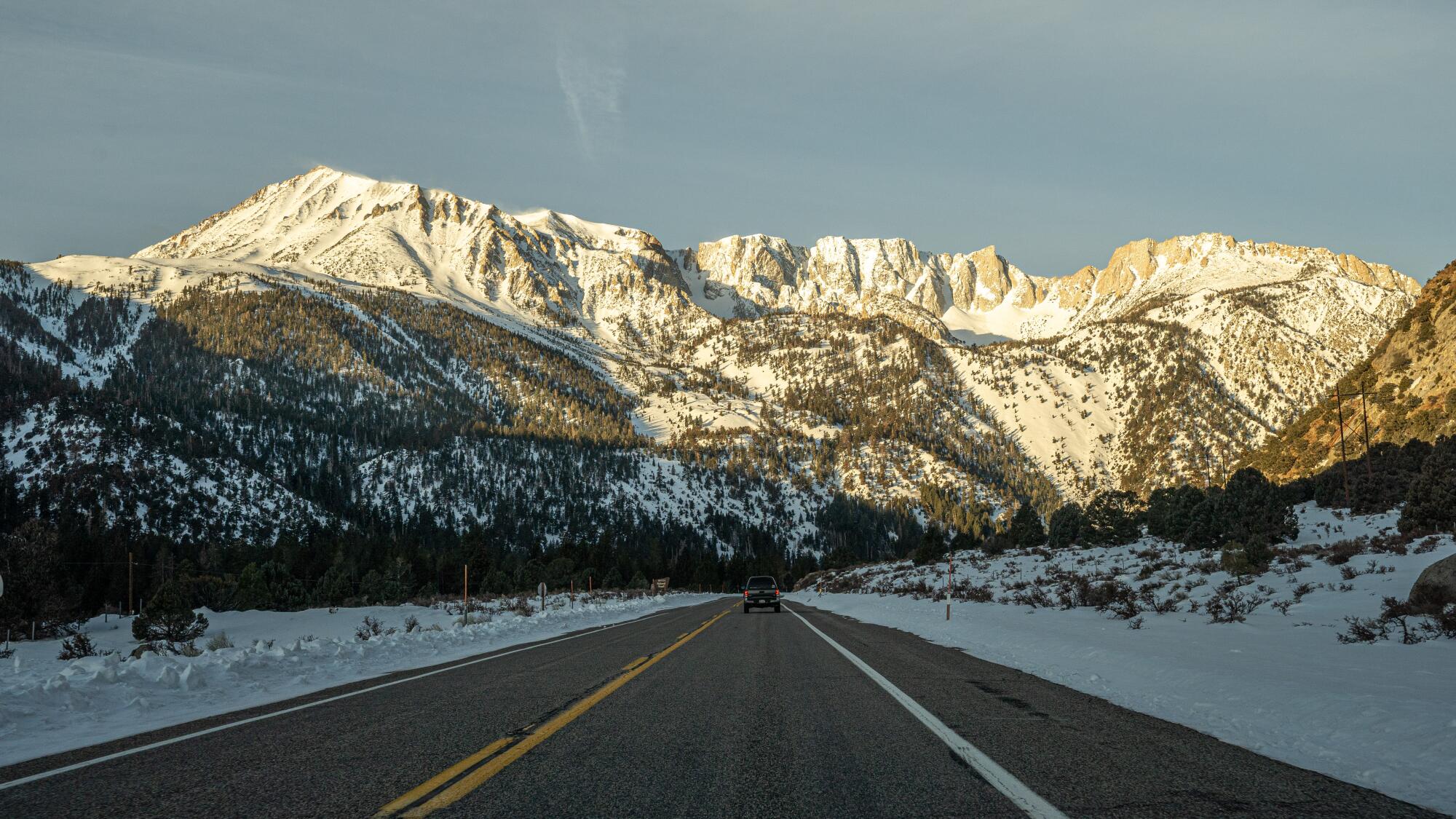 A road leads to snowy mountains. 