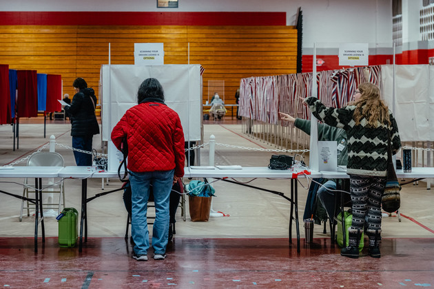 Voters cast their ballots inside the Pinkerton Academy high school polling place.