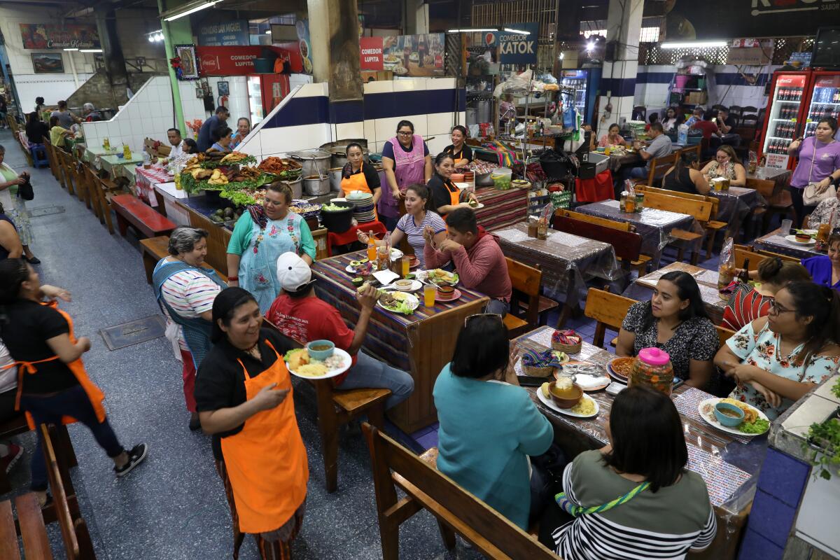 Guests eat in a food court with a variety of different restaurants serving different types of food.