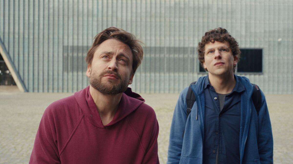 Two men stand outside looking upward in "A Real Pain."