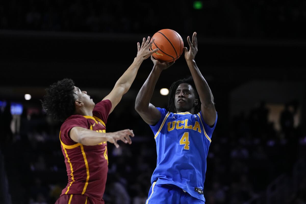 UCLA guard Will McClendon shoots against USC guard Oziyah Sellers on Saturday at the Galen Center.