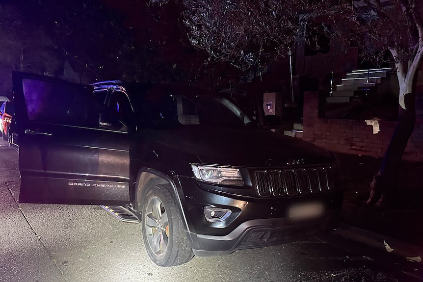 A black Jeep car with the door open