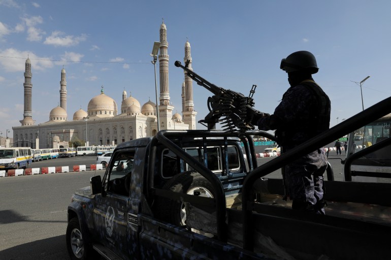 A police trooper mans a machine gun mounted on a patrol vehicle, outside a rally held to commemorate ten Houthi fighters killed by the U.S. Navy in the Red Sea, in Sanaa, Yemen January 5, 2024. REUTERS/Khaled Abdullah