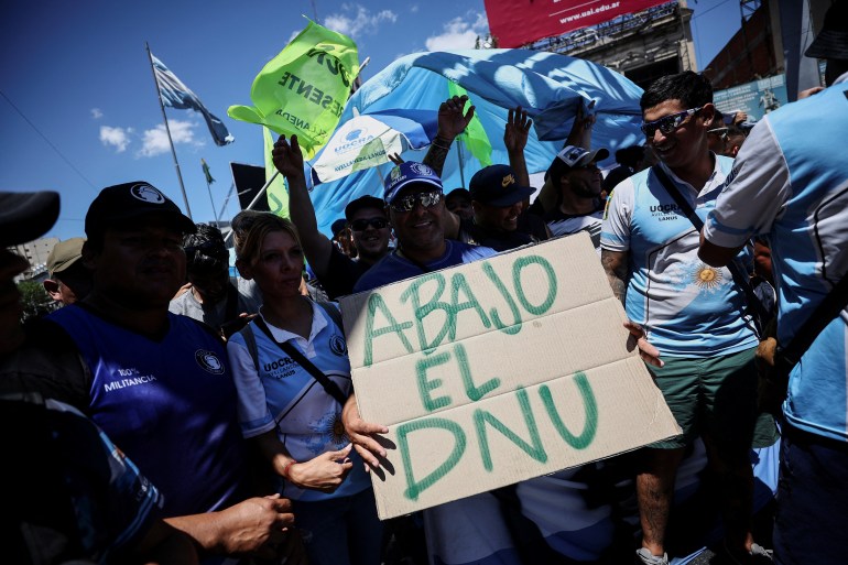 Demonstrators hold a placard that reads "Down with the decree"