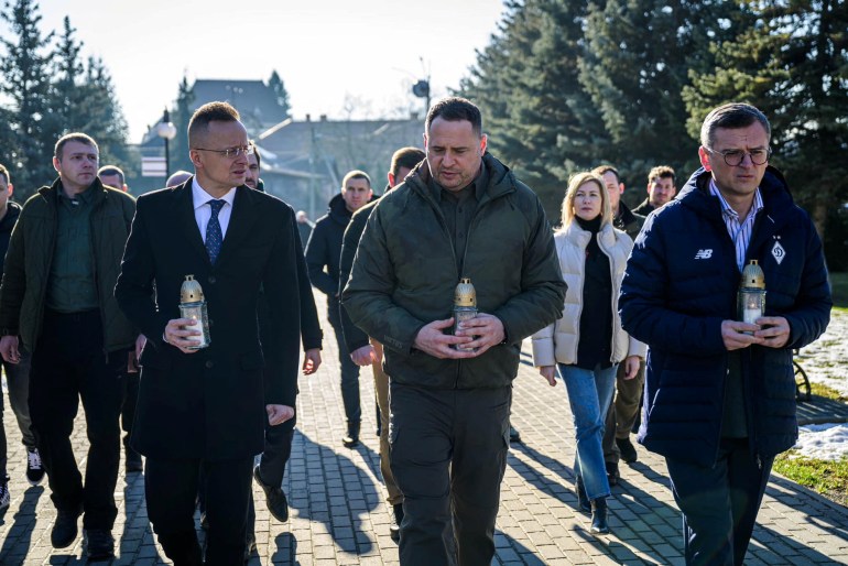 Ukrainian Foreign Minister Dmytro Kuleba, Head of the Office of the President of Ukraine Andriy Yermak and Hungarian Minister of Foreign Affairs and Trade Peter Szijjarto paying their respects to fallen Ukrainian soldiers. They are carrying small lanterns with candles inside