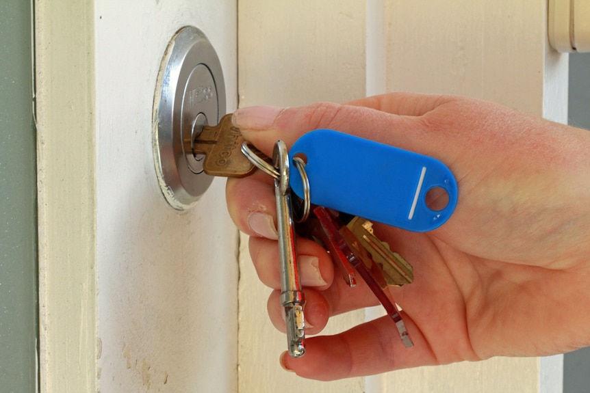 Woman opens a door with a key