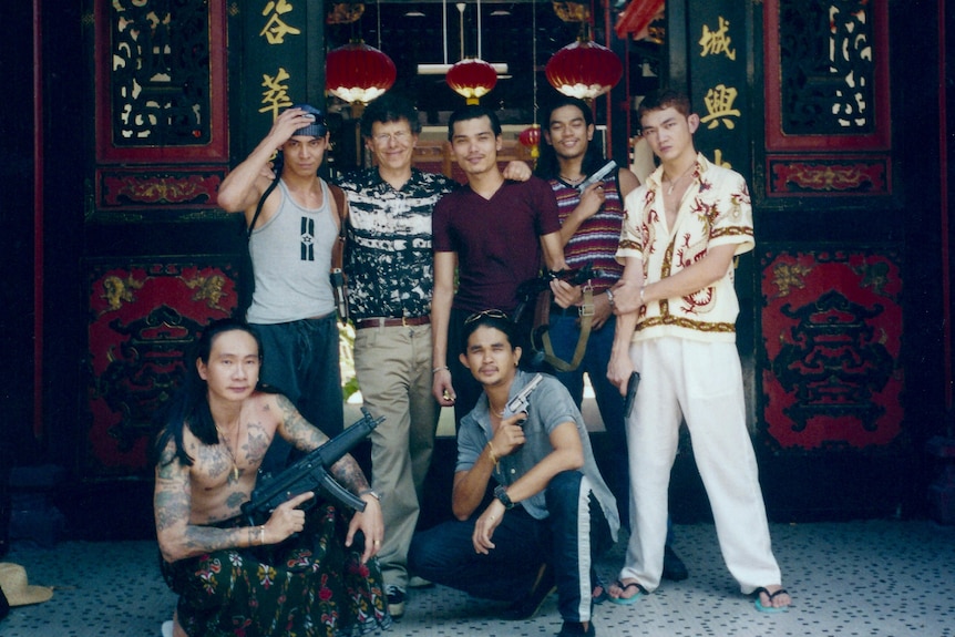 A group of 7 men men, two crouching, three holding guns.