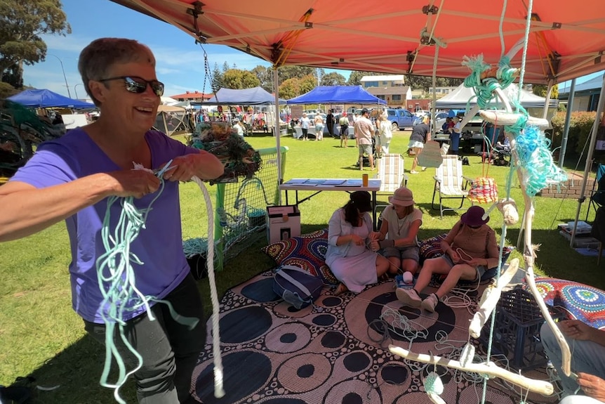 People sit in the shade and weave