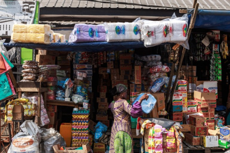 Mrs Bakare Kehinde, a retire principal, holds various types of plastic plates in her store