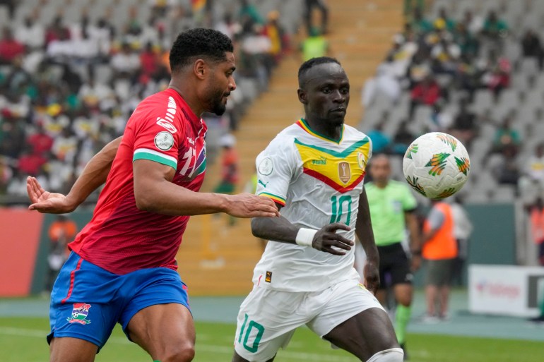 Senegal's Sadio Mane, right, vies for the ball with Gambia's Saidy Janko during the African Cup of Nations Group C soccer match between Senegal and Gambia at the Charles Konan Banny stadium in Yamoussoukro, Ivory Coast, Monday, Jan. 15, 2024. (AP Photo/Sunday Alamba)