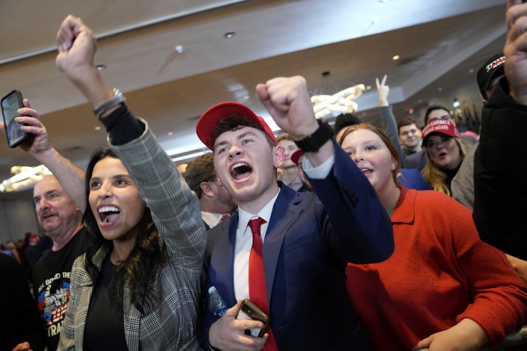 Trump supporters raise fists and yell triumphantly at campaign headquarters.