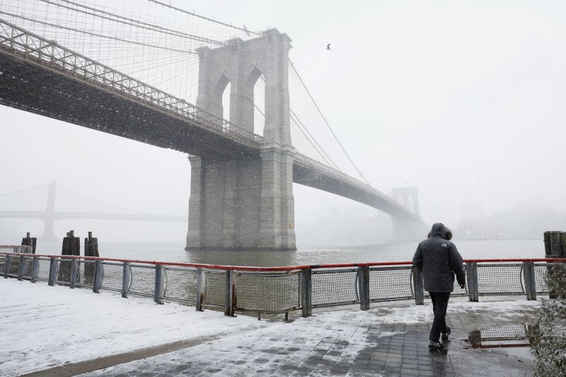 Snow falls over the Brooklyn Bridge in New York City on Friday. A third winter storm in the past few days descends on the tri-state area dumping up to five inches of snow in some spots which will be followed by freezing cold temperatures over the weekend. Photo by John Angelillo/UPI