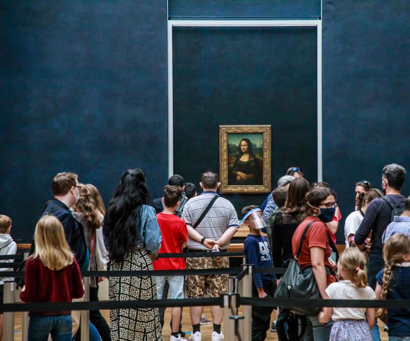 Visitors wearing protective face masks line up to see Leonardo da Vinci's Mona Lisa at the Louvre Museum in Paris, France in 2020. Protesters attempted to deface the Mona Lisa Sunday by throwing soup at the masterpiece, which was unharmed. EPA-EFE/CHRISTOPHE PETIT TESSON