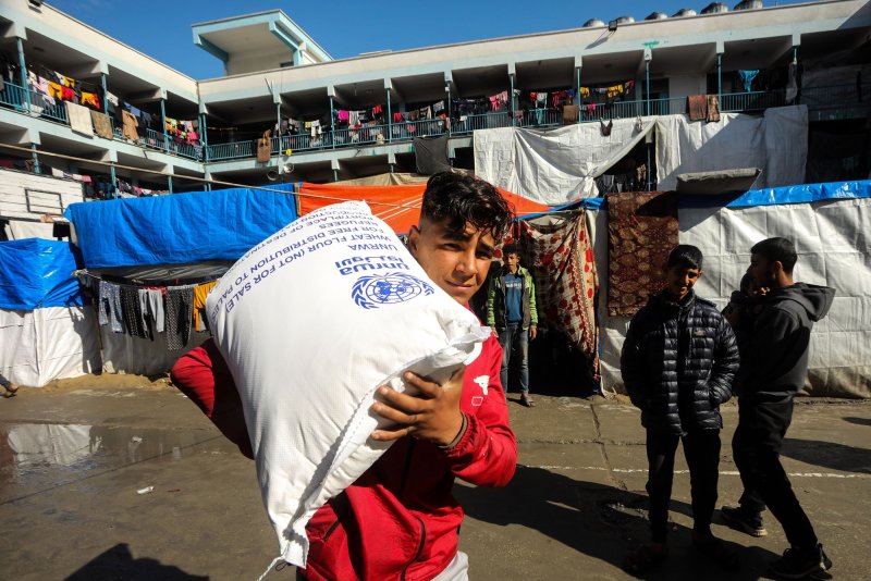 Displaced Palestinians receive flour bags at the United Nations Relief and Works Agency for Palestine Refugees (UNRWA) school in Rafah in the southern Gaza Strip on Sunday, January 28, 2024, amid ongoing battles between Israel and the Palestinian fighters. Israel has alleged several UNRWA staff were involved in Hamas's October 7 attack, leading some key donor countries to suspend funding and the agency to fire several staff over the claims, in a row between Israel and UNRWA a day after the UN's International Court of Justice ruling. Photo by Ismael Mohamad/UPI