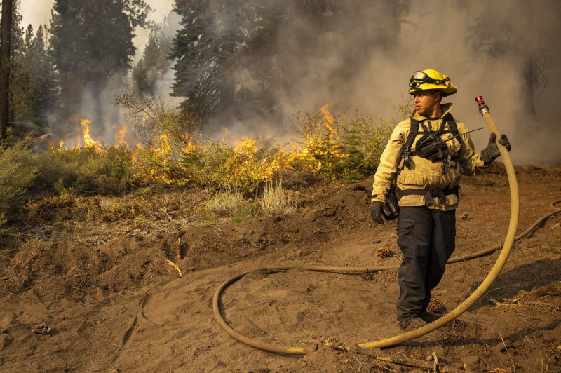 Firefighter Kirk Steven monitors a fire line as he allows fuel to be burned off during the Caldor wildfire near Meyers, Calif., in 2021. The Department of Interior on Tuesday announced $138 million to help prevent wildfires and help areas affected by them. File Photo by Peter DaSilva/UPI