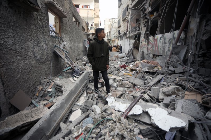 A Palestinian youth stands amid damage to his home caused by Israeli air strikes in Rafah in the southern Gaza Strip on Wednesday. Israeli forces said they have inflicted a "large number" of casualties on Hamas fighter this week as they advance in the city of Khan Younis. Photo by Ismael Mohamad/UPI