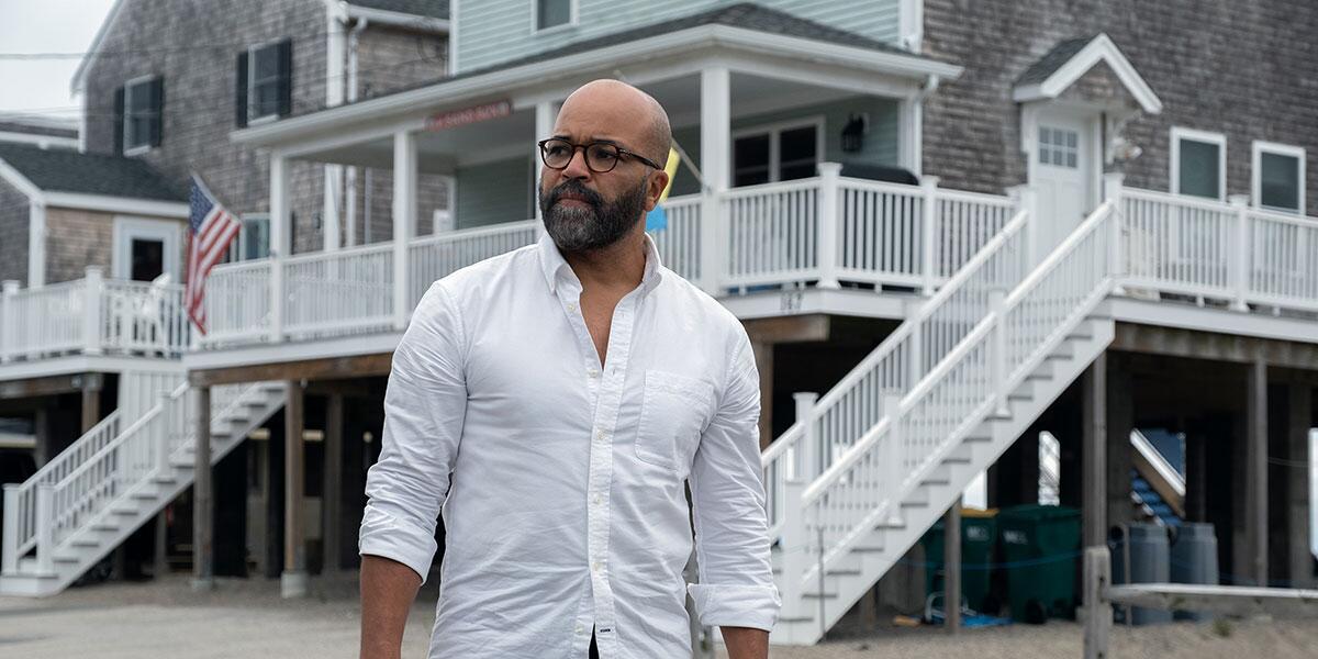 A man stands outside a beach house.