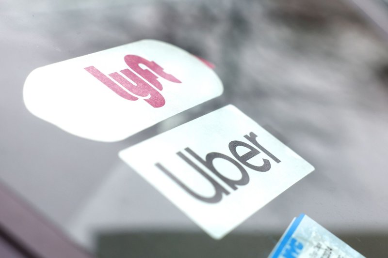 Lyft and Uber brand logos show up on the dashboard of a car near LaGuardia Airport on February 26, 2023, in New York City. The Labor Department tightened a new rule on how independent contractors can be identified, like the drivers used by the two companies. File Photo by John Angelillo/UPI