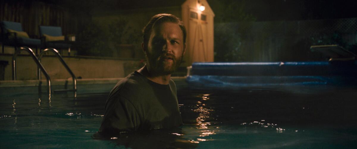 A man stares into the deep end of a swimming pool.