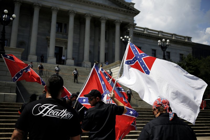 Members of a rally, which was led by the Loyal White Knights of the Ku Klux Klan, a group from Pelham, North Carolina, stand in front of the South Carolina State House, July 18, 2015, in Columbia, South Carolina; the rally was held to protest the removal of a Confederate battle flag from the State House grounds. Photo by Veasey Conway/UPI