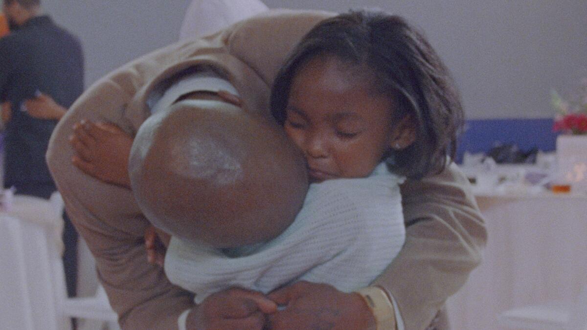 A father and daughter hug.