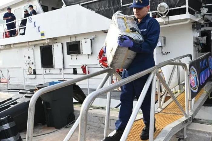 A crew member from Coast Guard Cutter Margaret Norvell offloads bags of cocaine Tuesday at Coast Guard Base Miami. Six suspected smugglers were detained aboard the Norvell after two separate drug smuggling seizures in the international waters of the Caribbean Sea. Photo by Petty Officer 2nd Class Diana Sherbs courtesy of USCG