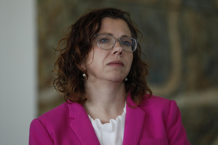 Amanda Rishworth wearing a pink blazer and white blouse, looking to the right