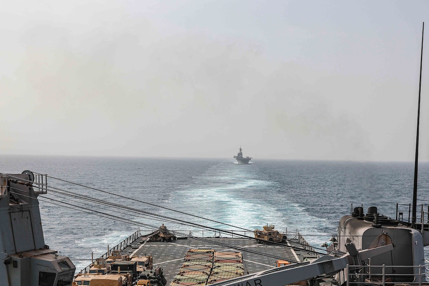 The back of a ship is open and the image looks out towards the wake in the water of the Bab al-Mandeb strait near the Red Sea 