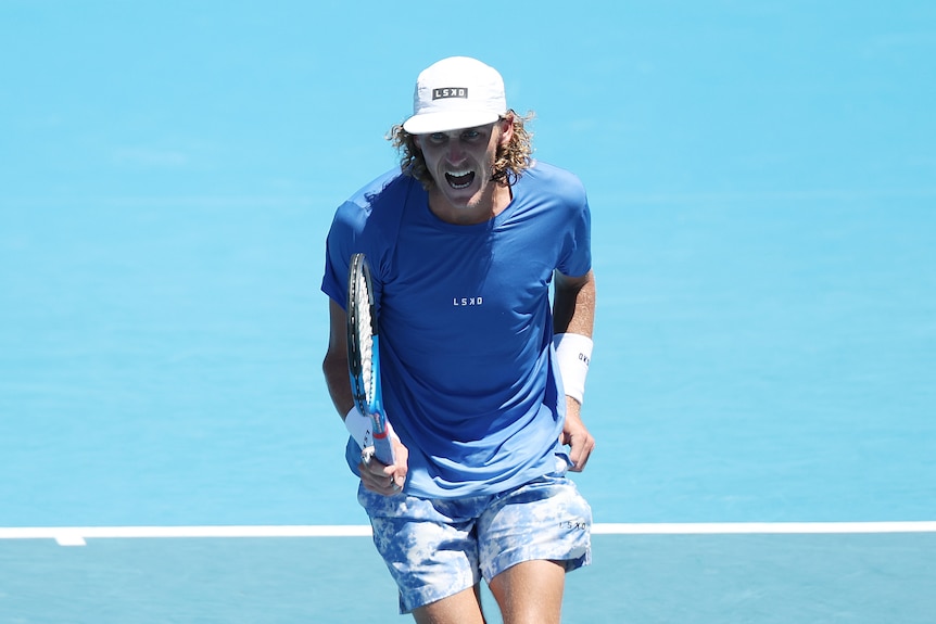 A man celebrates winning a point in a tennis match