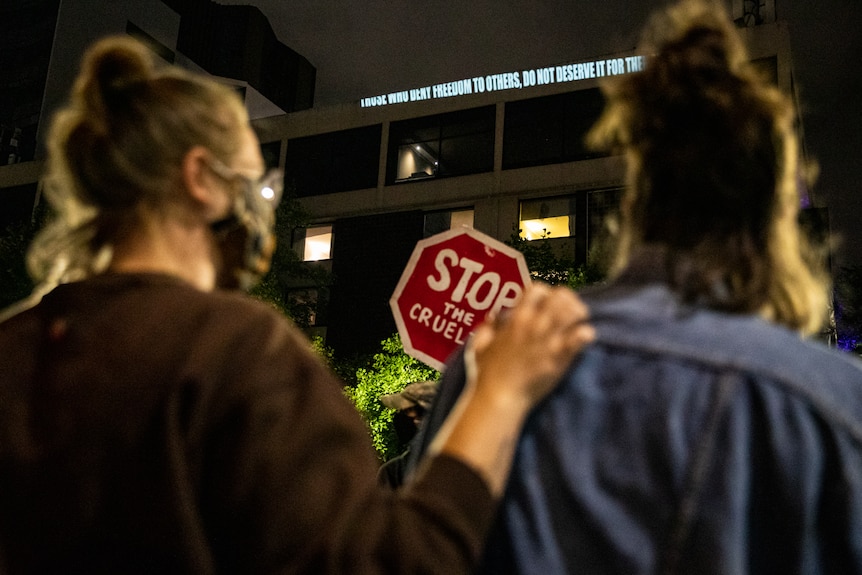 Protestors stand outside a hotel