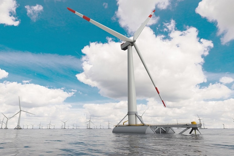 Picture of wind turbines in the middle of the ocean. A blue cloudy sky above.