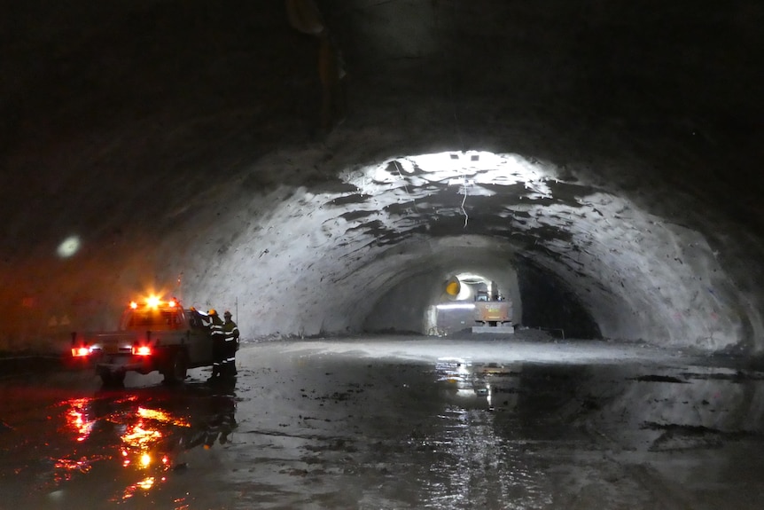 A dimly lit tunnel with an arched roof.